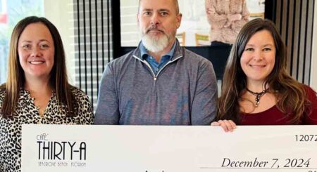 From left to right: Carly Barnes, Executive Director of Caring and Sharing of South Walton; David Kessler and Jackie Maliszewski, owners of Café Thirty-A, hold a ceremonial check for $81,000 raised during the 2024 Christmas Charity Ball.