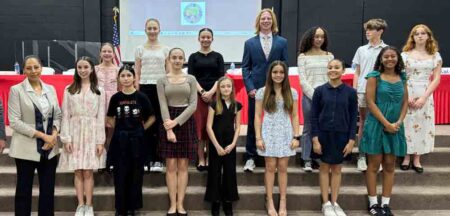 A group of middle school students pose on stage at Florida’s first National Civics Bee in Fort Walton Beach.