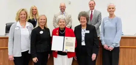 A group of local officials and Okaloosa Saves representatives pose for a photo with a proclamation recognizing Okaloosa Saves Week and America Saves Week.