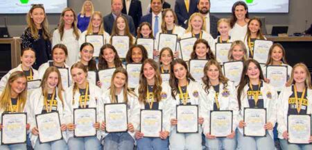 The Ruckel Middle School Cheerleading Team poses with certificates after being recognized by the Okaloosa County School Board for winning a national championship.