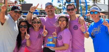 A smiling group from Recess After Dark celebrates with a trophy at the 7th Annual Mac & Cheese Festival at Destin Commons.