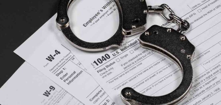 Open handcuffs on tax forms, symbolizing financial crime, fraud, or tax-related legal issues.