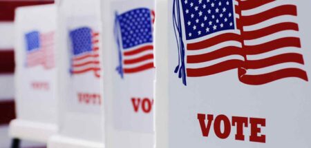 Voting booths lined up with American flag designs and the word "VOTE."