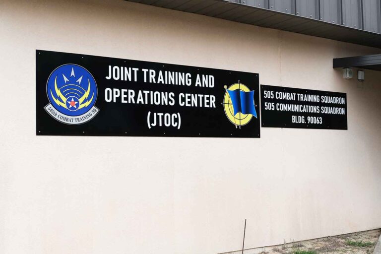 photo of a building with brown signs that have wording “Joint Training and Operations Center (JTOC) and 505th Combat Training Squadron and 505th Communications Squadron”
