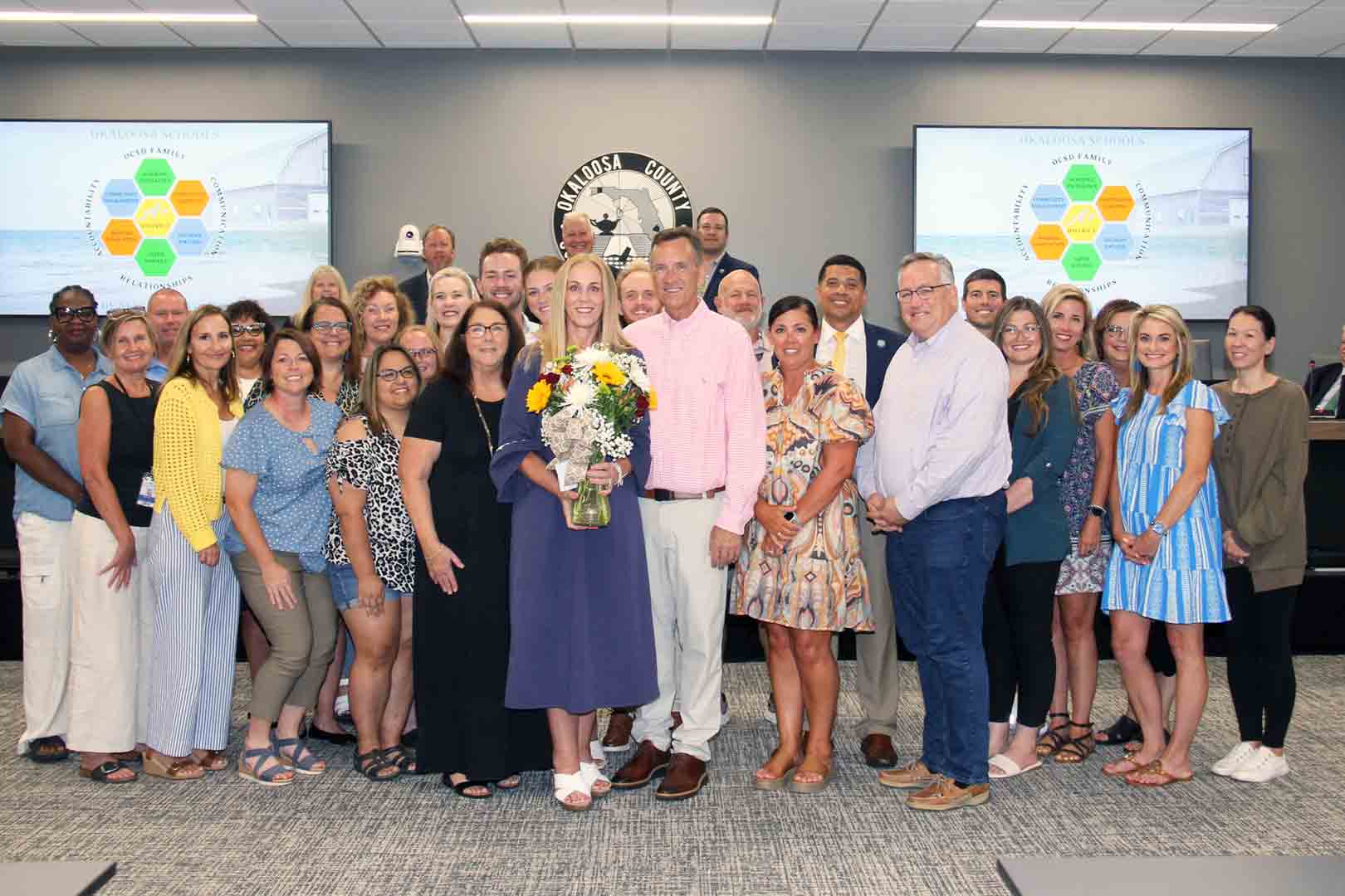 Group photo of Holly Tew with family, school staff, and board members.