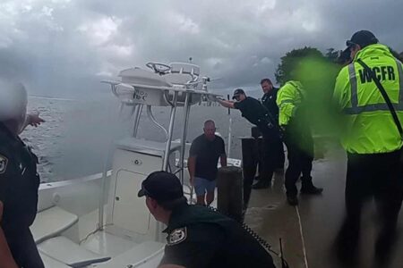 Deputies and rescue crews help man off boat during stormy rescue