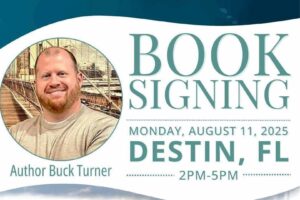 Author Buck Turner smiles in front of a scenic bridge backdrop.