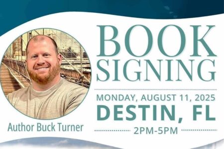 Author Buck Turner smiles in front of a scenic bridge backdrop.