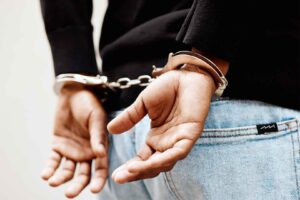 Close-up of a person in handcuffs with hands behind their back