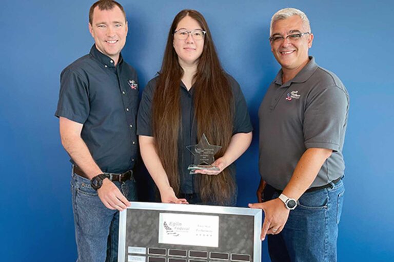 Elaine Carr holding award, standing with Eglin FCU colleagues