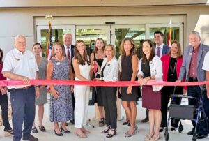 Northwest Florida State College leaders, trustees, and community members cut a red ribbon in front of the new School of Nursing building at the Niceville Campus.