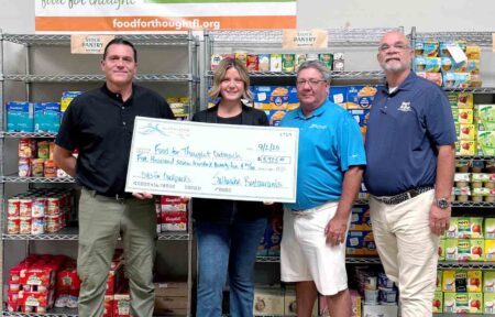 Saltwater Restaurants presents $5,725 check to Food For Thought Outreach from Bites for Backpacks campaign.