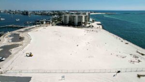 Aerial view of the newly acquired waterfront property in Destin beside existing condominiums.