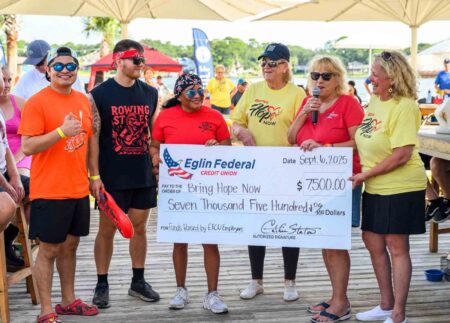 Eglin Federal Credit Union employees present a $7,500 donation check to Bring Hope Now during the Dragon Boat Race and Festival.