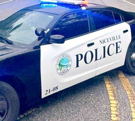 A Niceville Police Department patrol vehicle with emergency lights activated blocks a roadway.