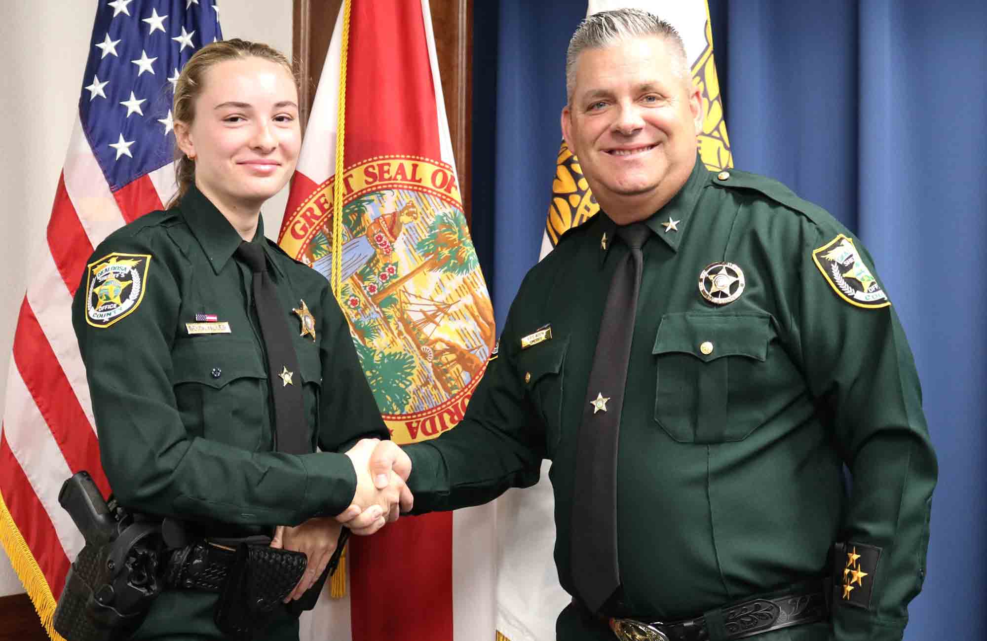 Deputy Devon Miller shakes hands with Sheriff Eric Aden.