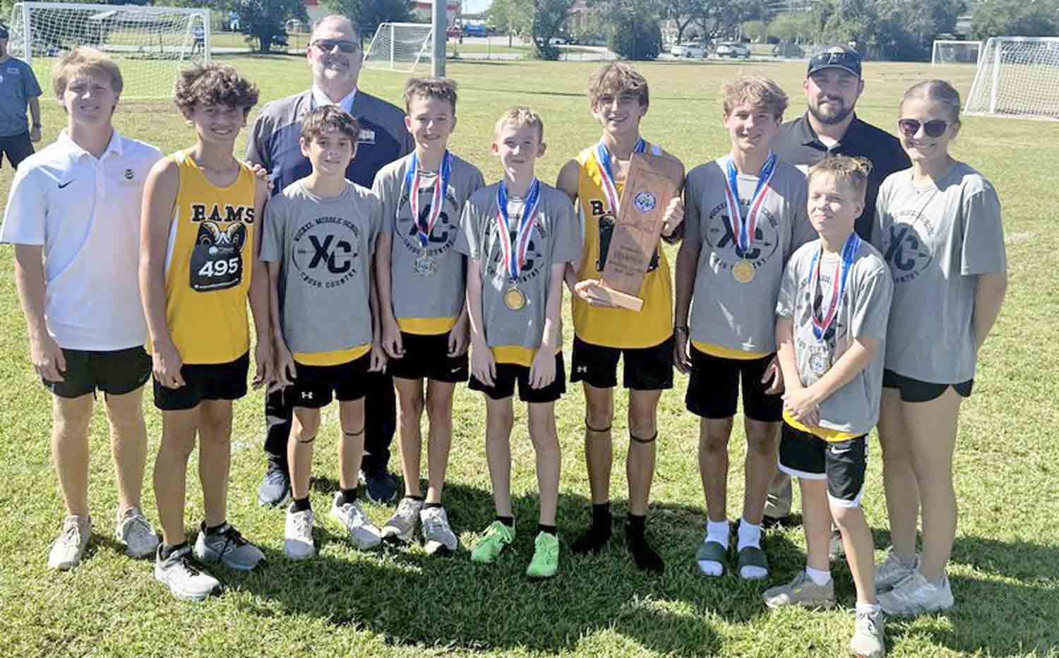 Ruckel Middle School boys cross country team poses with coaches and administrators after winning the 2025 county championship at Twin Oaks Complex.