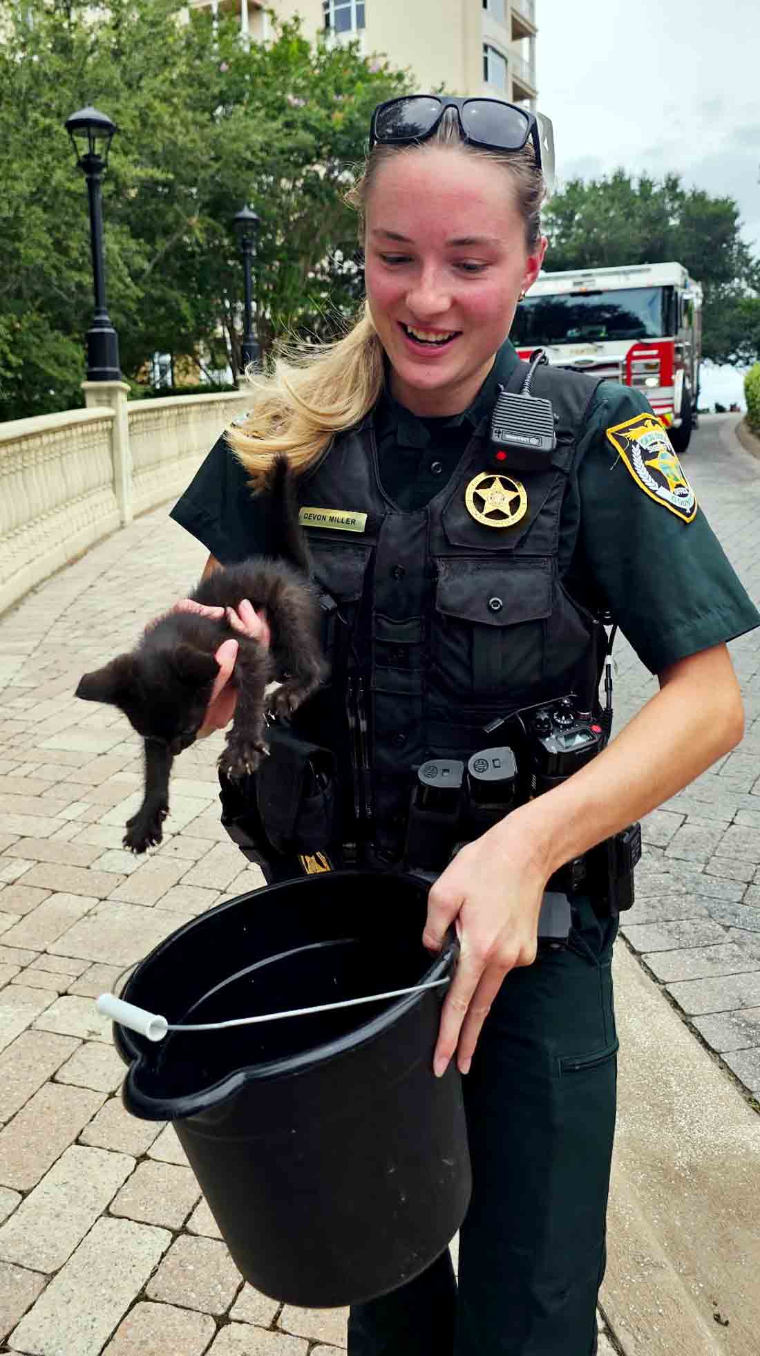 Deputy Devon Miller holds a rescued kitten after a storm drain rescue in Destin.