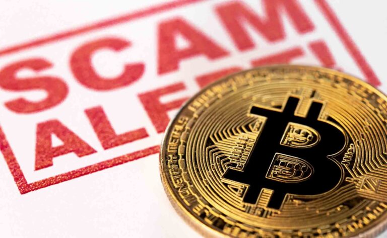 Walton County man loses $400K in online crypto scam Bitcoin coin placed on paper with the words “Scam Alert.”