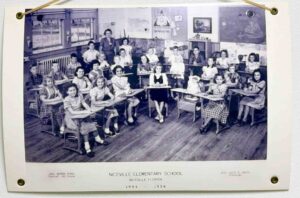 Historic 1953–1954 Niceville Elementary School classroom photo showing students seated at wooden desks with their teacher standing at the back.
