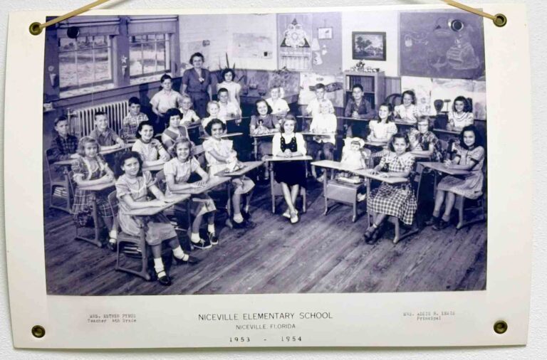 Historic 1953–1954 Niceville Elementary School classroom photo showing students seated at wooden desks with their teacher standing at the back.