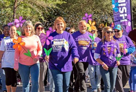 Participants walk beneath falling bubbles during the Walk to End Alzheimer’s at Northwest Florida State College in Niceville.