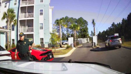 WCSO deputies say Lamborghini driver ran after abandoning car A Walton County Sheriff’s Office deputy stands beside a red sports car parked in front of an apartment building inside a gated complex.