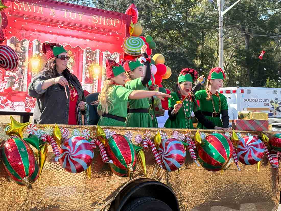 Children dressed as Christmas elves ride a festive float decorated with candy and ornaments during the Niceville Christmas Parade.