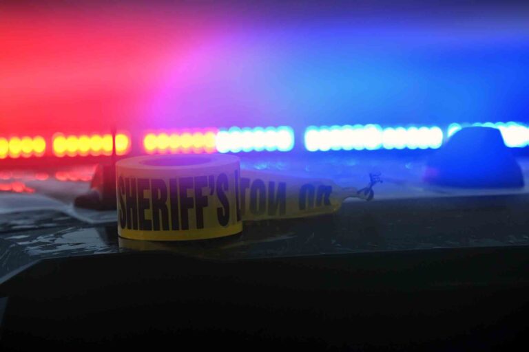 Home invasion turns deadly in Walton County; suspect, victim killed Sheriff’s office crime scene tape sits on a patrol vehicle illuminated by red and blue emergency lights.