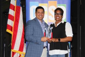 Superintendent Marcus Chambers stands with Nicole Hardin holding an award at the Okaloosa County School District’s 2026 Education Staff Professional of the Year ceremony.