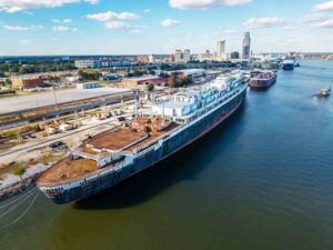 The SS United States docked in Mobile, Alabama, with the city skyline in the background.
