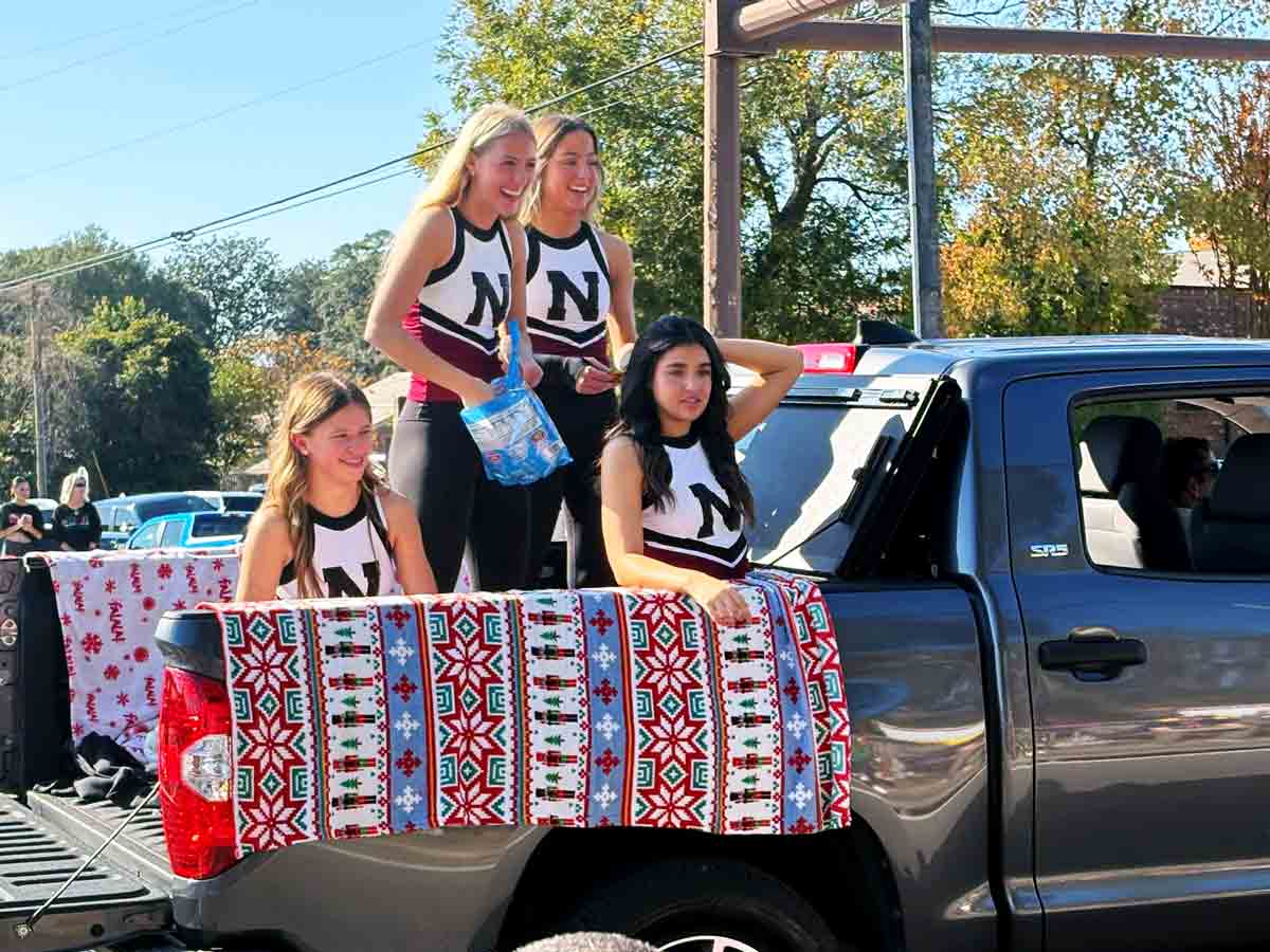 Niceville High School cheerleaders ride in a pickup truck during the Niceville Christmas Parade.