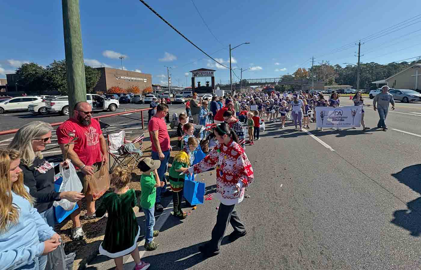 Parade participants hand out treats to children as spectators line John Sims Parkway during the Niceville Christmas Parade.