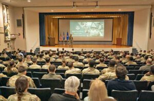 Airmen and civilians seated in an auditorium listen to Brig. Gen. Mark Massaro during a 96th Test Wing town hall at Eglin Air Force Base.