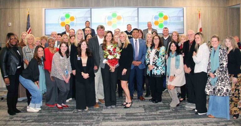 Destin Middle principal Dr Belinda Small moves into OCSD leadership Group photo of Dr Belinda Small surrounded by colleagues and supporters at an Okaloosa County School Board meeting.