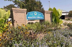 The Lannie L. Corbin Municipal Complex sign at City Hall in Niceville, Florida, surrounded by landscaped flower beds.