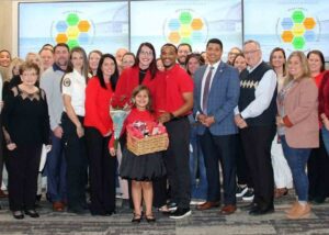 Haleigh Moore stands with family members, Okaloosa County School District staff, and school officials during her assistant principal recognition ceremony.