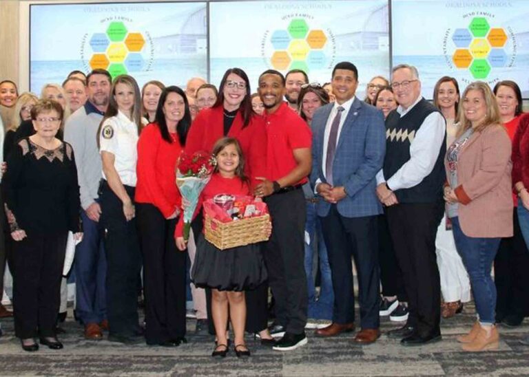 Haleigh Moore stands with family members, Okaloosa County School District staff, and school officials during her assistant principal recognition ceremony.