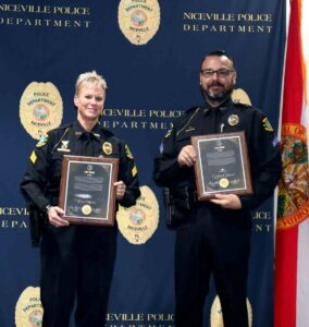 Two Niceville Police Department officers stand holding Unit Award plaques during the department’s annual awards ceremony.