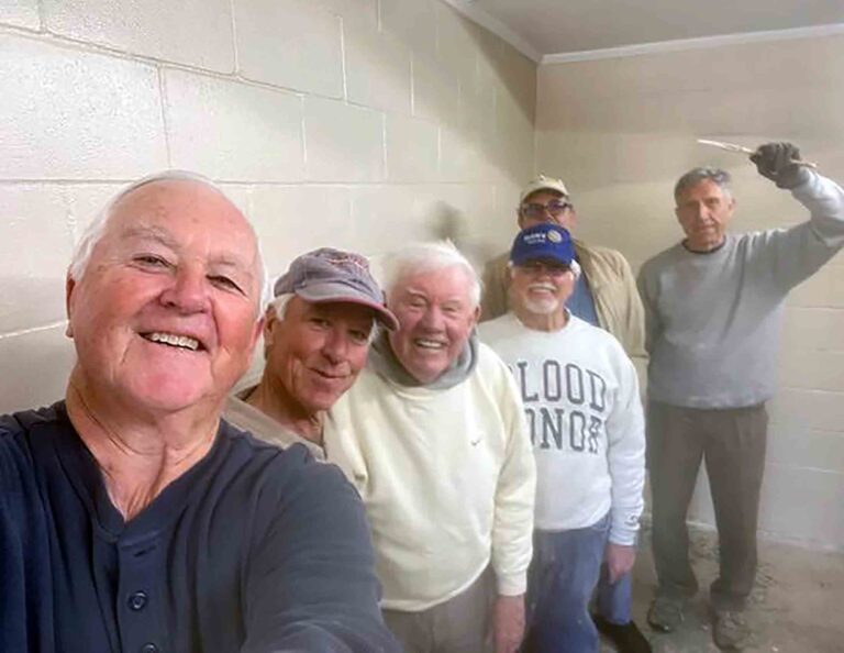 Mid-Bay Bridge Rotary Club volunteers pose inside Turkey Creek Park restrooms during renovation painting work in Niceville.