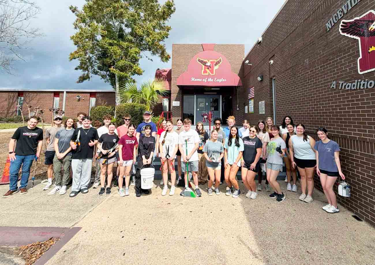 Niceville High School Tri-M Honor Society students gather after a campus beautification service project.