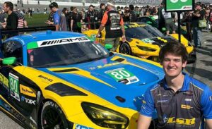 Jackson Shirey stands beside a Mercedes-AMG GT race car on the grid at Daytona International Speedway.
