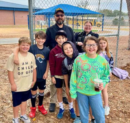 Plew Elementary students pose with a police officer and deputy during the High Five a Hero event in Niceville.