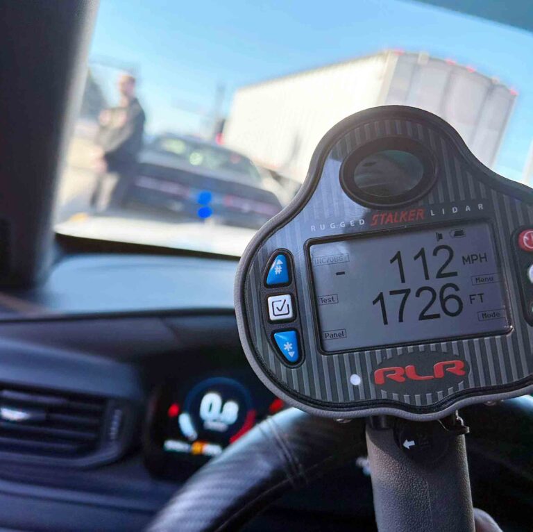 Law enforcement lidar device displaying 112 mph speed reading during traffic stop
