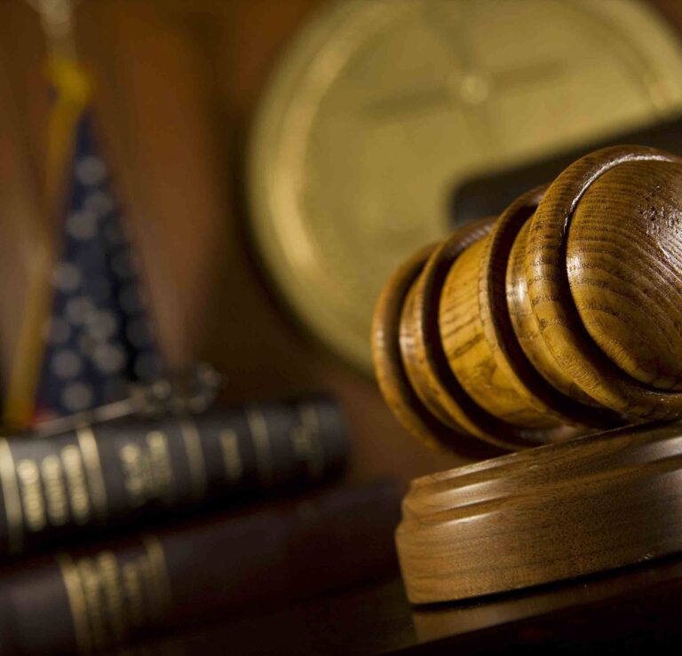 Armed meth trafficking charges filed against Walton man Wooden judge’s gavel resting on a sound block with law books, a clock, and an American flag in the background.