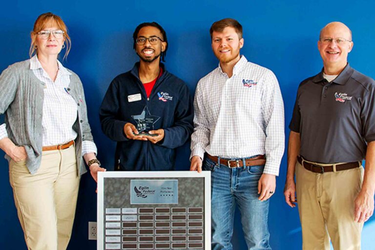 Eglin Federal Credit Union employees pose with Jabari Clayton holding a 5-Star Performer award and recognition plaque.
