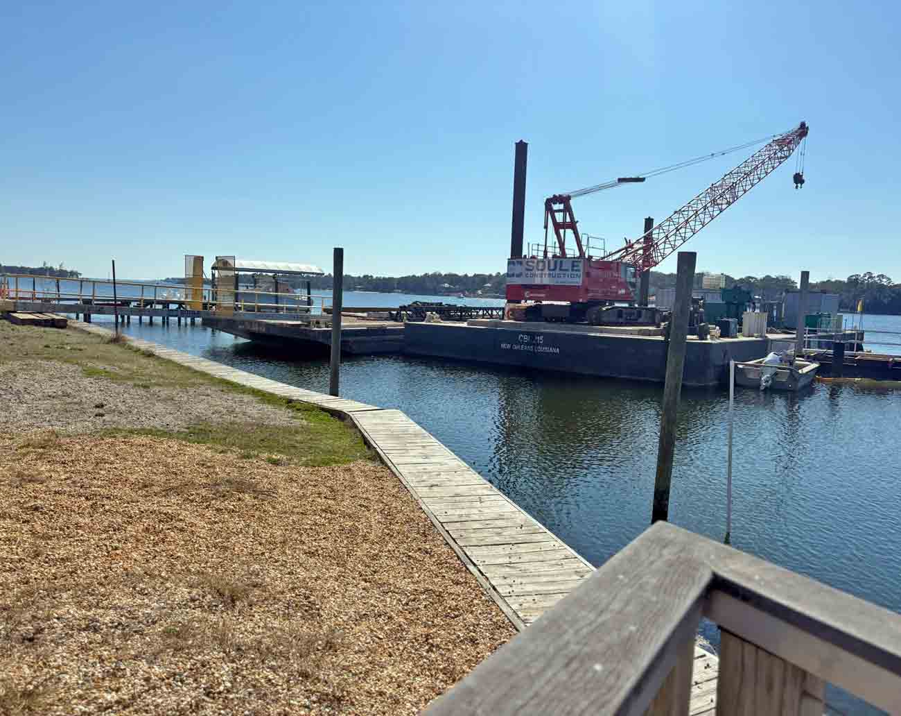 Construction barge and crane positioned near the Old Town Landing waterfront in Niceville as dock and pier work begins.