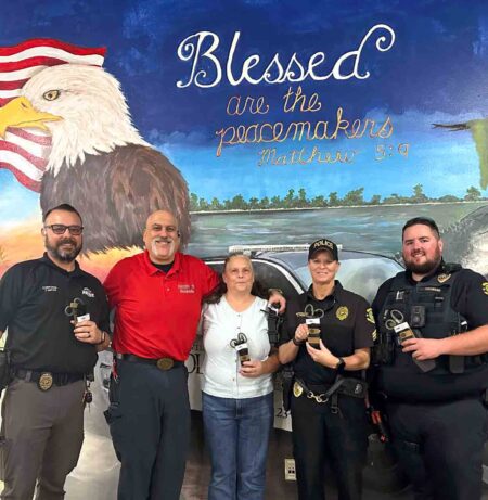 Braxton College representatives present Stop the Bleed kits to Niceville Police Department officers.