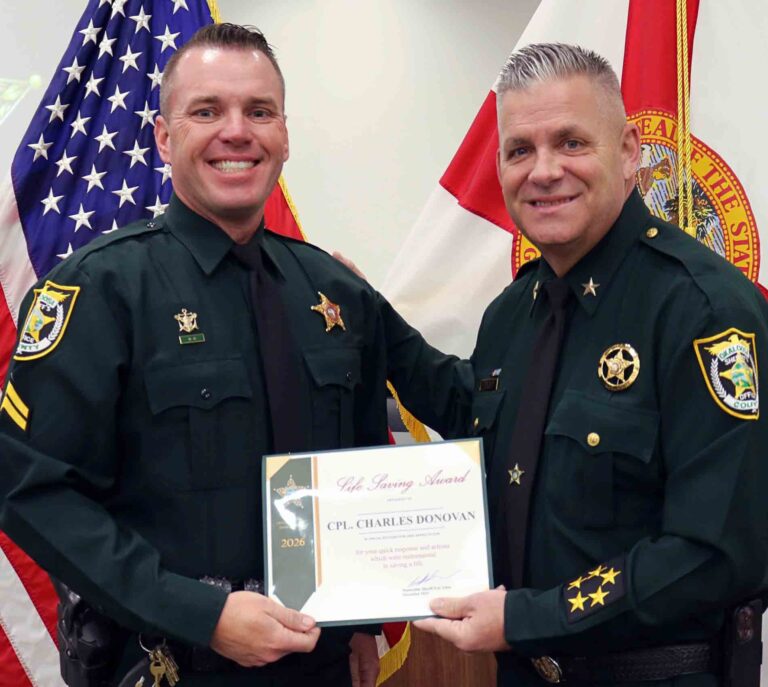 Corporal Charles Donovan receives the OCSO Life Saving Award from Sheriff Eric Aden during a presentation ceremony.