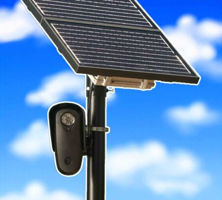 Solar-powered license plate reader camera mounted on a pole against a blue sky.